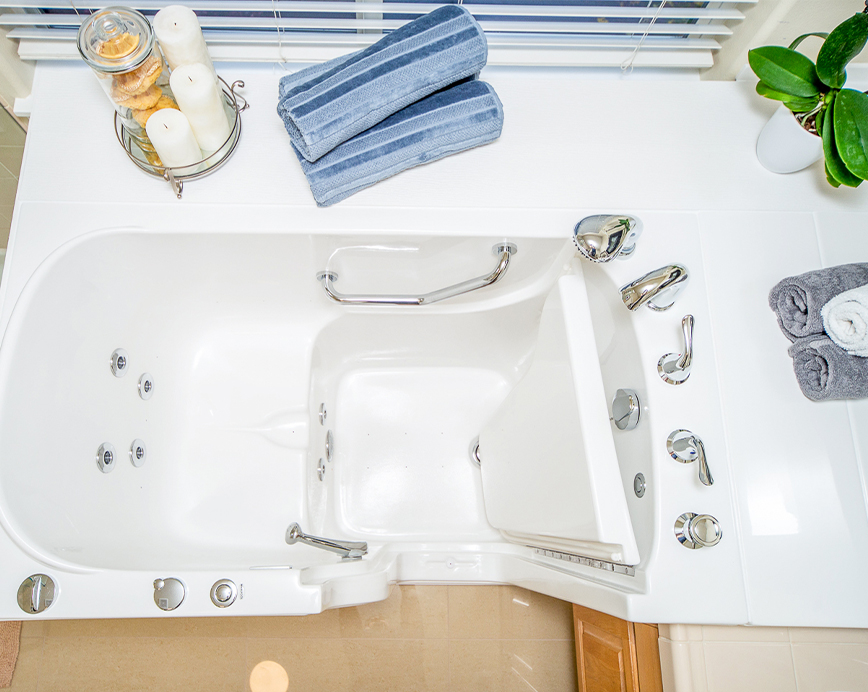 The image depicts a bathroom with a white bathtub, sink, and toilet, along with blue towels and other bathroom accessories.