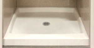 The image shows a white bathroom sink with a visible drain set into a countertop within an enclosed space, possibly a cabinet or vanity unit.