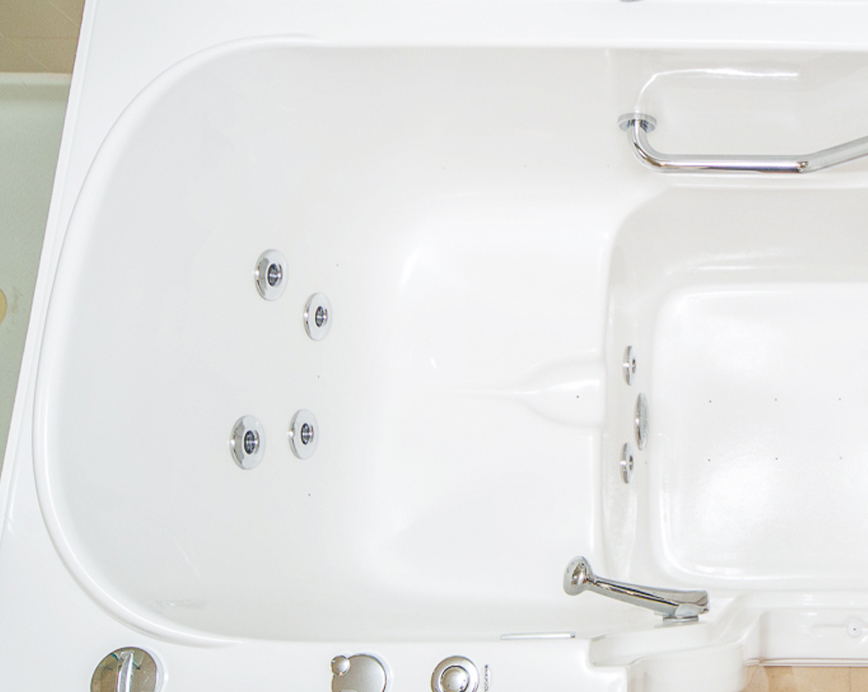 The image shows a white bathtub with a shower attachment, featuring chrome fixtures and a clean appearance.