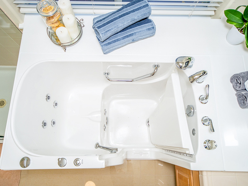 The image shows a modern bathroom with a freestanding bathtub, a sink with a faucet, and a towel rack with towels on it.