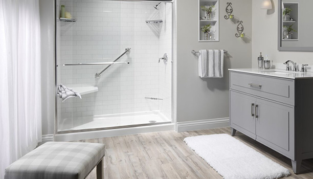 A well-lit bathroom with a walk-in shower, bathtub, and white vanity cabinets.